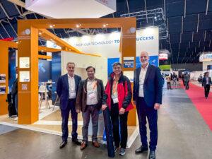 NSTIC (GaN) representatives meeting international partners at European Microwave Week 2025 exhibition hall.